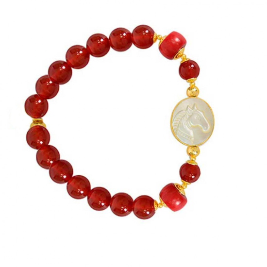 A horse seashell with a red coral stone, and a red agate stone