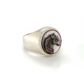 A wide silver ring with a small two-tone horse seashell